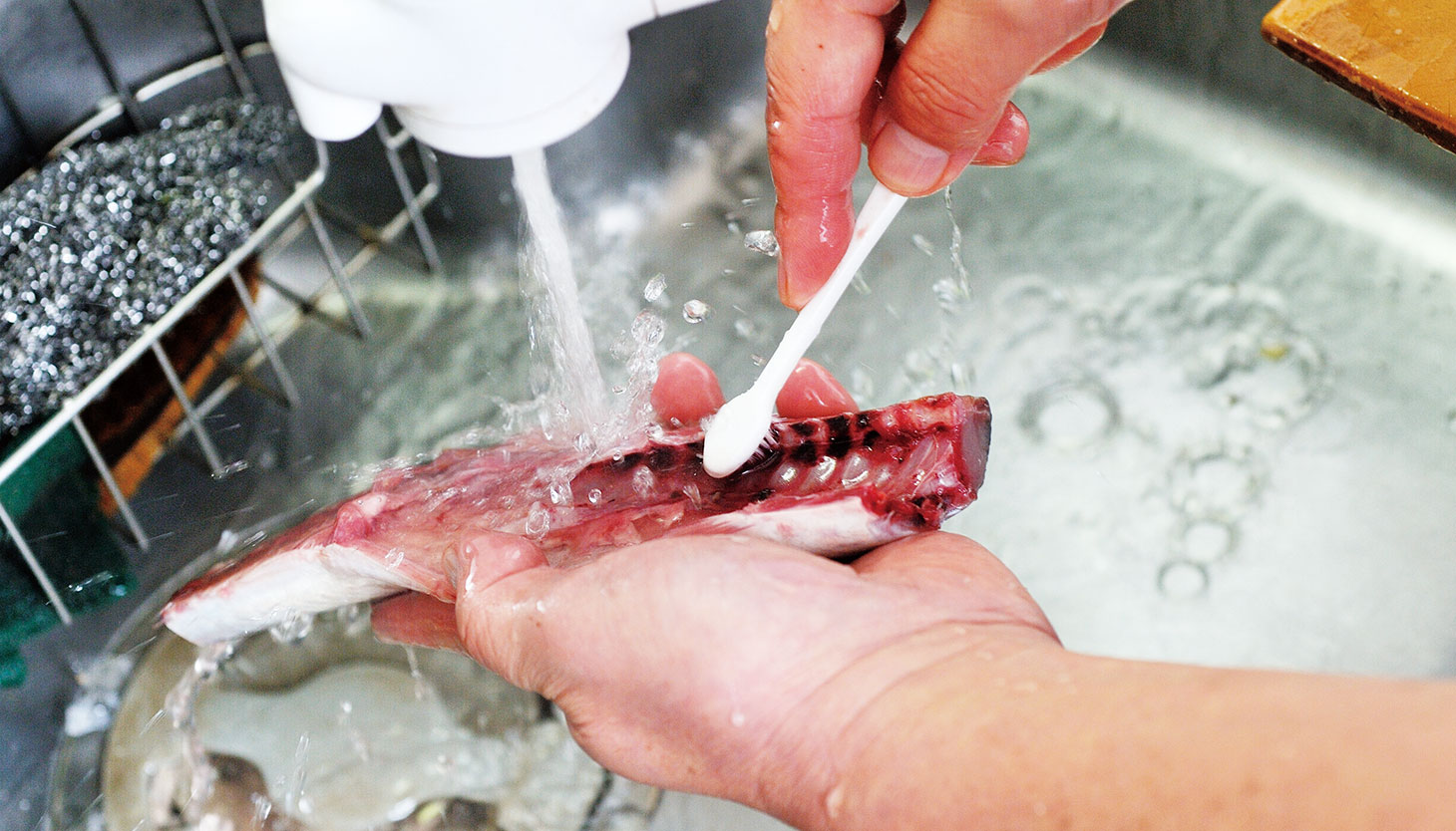 骨の部分の血を流水で丁寧に洗い流す
