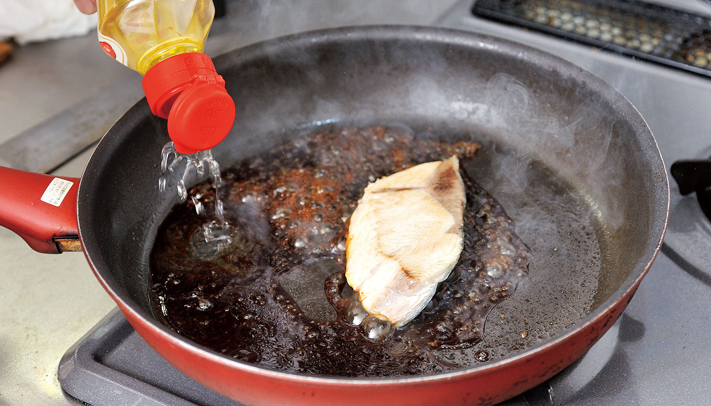 フライパンでぶりに調味料を加える照り焼きの工程