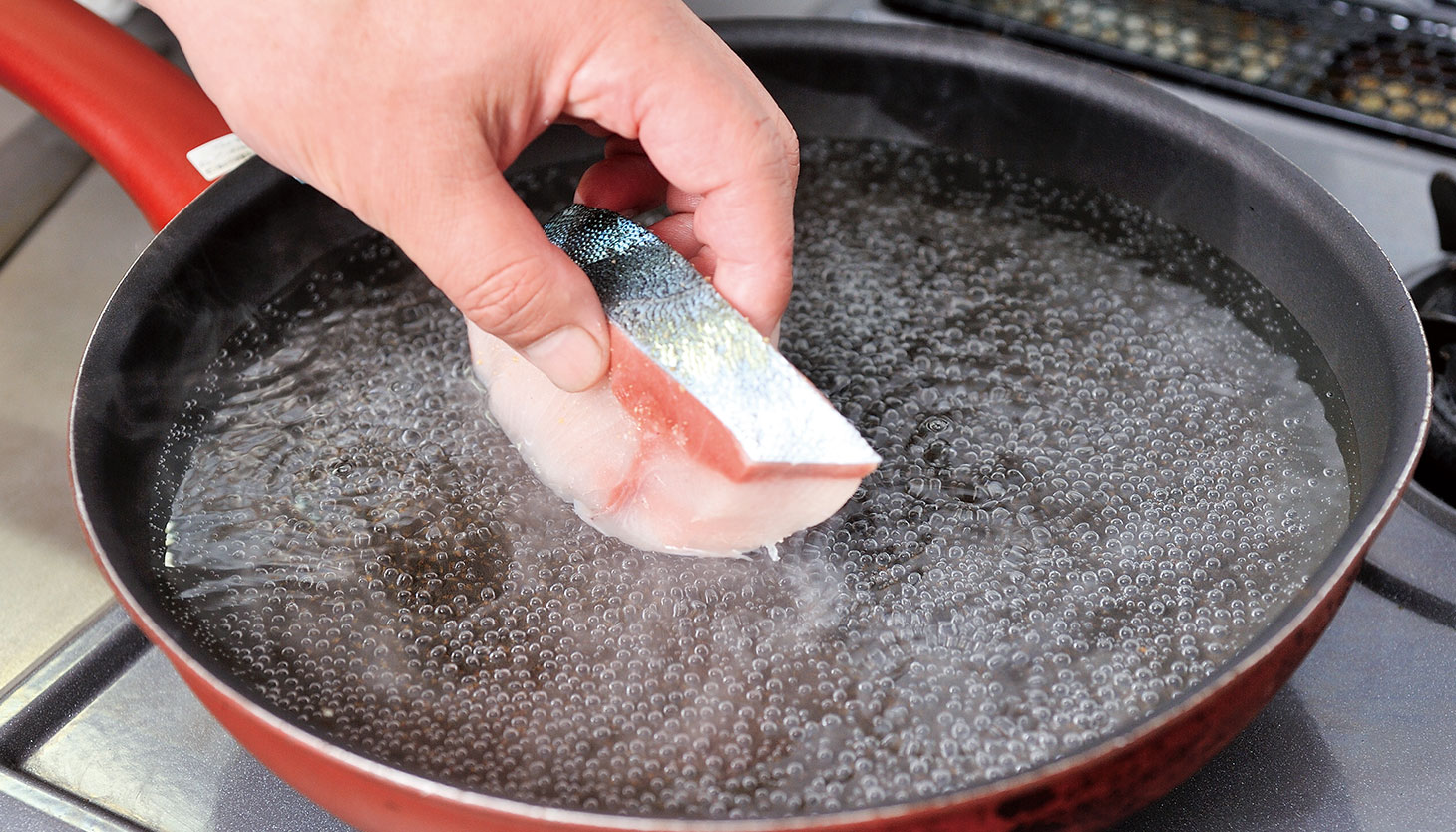 沸騰させない湯でぶりを茹でる湯煮の工程