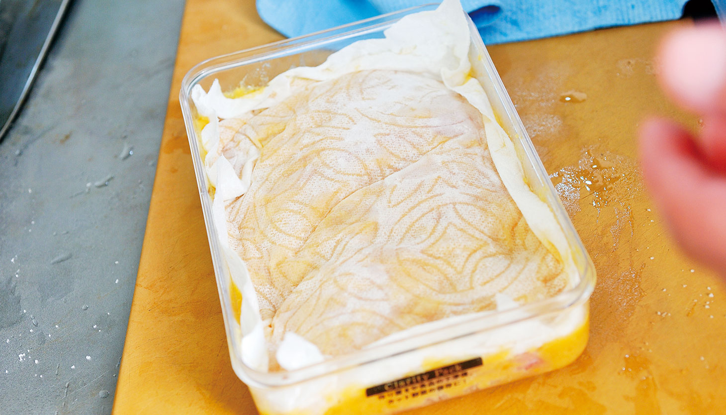 味噌漬けの魚にキッチンペーパーをのせて保存する様子