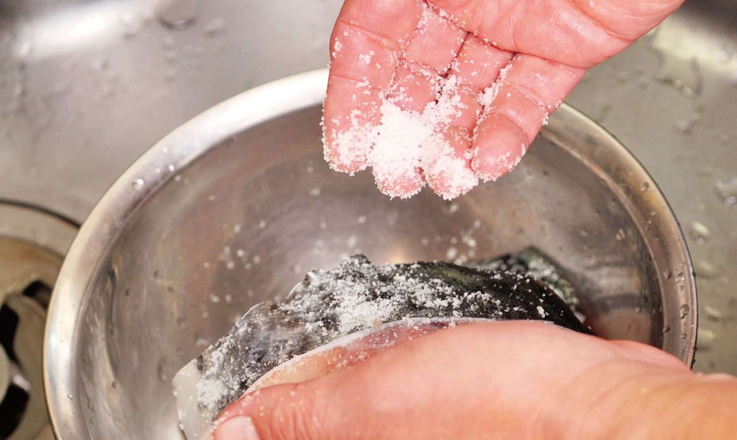 魚の洗い方。洗った魚に塩をまぶすシーン